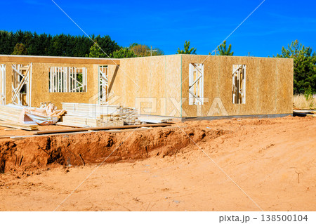 Construction workers build framing for new house structure using wooden beams frames on site 138500104