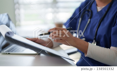 Healthcare professional diligently records patient information at a medical facility focusing on comprehensive patient care efficient documentation and data management 138501332