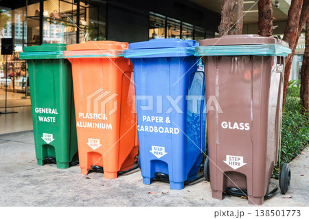 Recycling bins for different materials placed outside a shopping center in the afternoon Recycling bins for different materials placed outside a shopping center in the afternoon 138501773