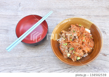 fried slice fermenting pork meat with spicy Japanese sauce topping white sesame and pickled ginger on plain rice in bowl 138502539