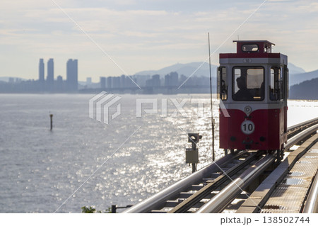 Colorful oceanfront capsule cars travel along an elevated coastal rail, offering scenic seaside views and a relaxed tourism experience over the water. High quality photo Colorful oceanfront capsule cars travel along an elevated coastal rail, offering scenic seaside views and a relaxed tourism experience over the water. High quality photo 138502744