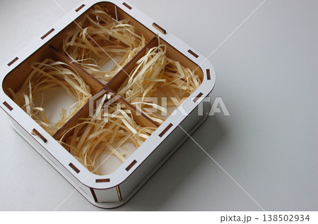 Painted box with separate empty niches inside for storing fragile items. Box with wood chips isolated on white with empty space Painted box with separate empty niches inside for storing fragile items. Box with wood chips isolated on white with empty space 138502934