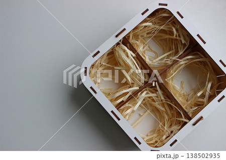 Wooden box with four compartments with bundles of wood shavings inside each Wooden box with four compartments with bundles of wood shavings inside each 138502935