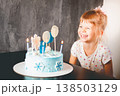The child blows out the candles on the cake.  138503129