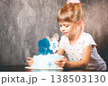 The child blows out the candles on the cake.  138503130