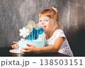 The child blows out the candles on the cake 138503151