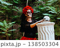 Day of the Dead. Portrait of a woman with a wreath of red roses and a skull on a column. 138503304