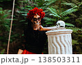 Day of the Dead. A woman with a wreath of red roses and a skull on a column. Artistic composition 138503311