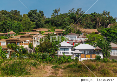 Tropical hillside villas surrounded by lush jungle vegetation on Koh Samui island, residential resort architecture in exotic landscape Tropical hillside villas surrounded by lush jungle vegetation on Koh Samui island, residential resort architecture in exotic landscape 138503947