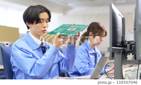 電子基板の構造を確認する作業着姿の男性エンジニア 電子基板の構造を確認する作業着姿の男性エンジニア 138507046