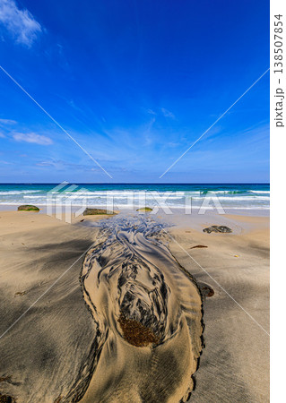 砂浜に描かれる水の流れと青い海が広がる海岸風景 138507854