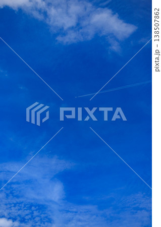 青空を横切る飛行機雲と広がる雲の風景 青空を横切る飛行機雲と広がる雲の風景 138507862