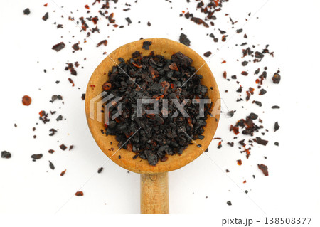 Macro Shot of Dried Isot Pepper Flakes in a Wooden Spoon Isolated on White Background - Turkish Chili 138508377