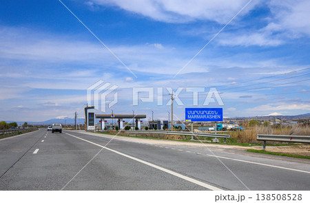 Empty highway leading to border checkpoint under clear sky 138508528