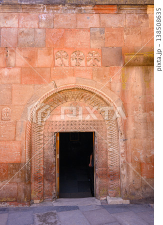 Stone archway with ornate carvings, leading into shadowed interior 138508635