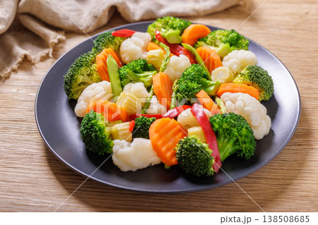plate of mix of steamed vegetables on wooden table plate of mix of steamed vegetables on wooden table 138508685