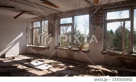 Abandoned Classroom With Broken Windows Debris. Sunlight Streaks Through Shattered Glass Onto Peeling Paint And Crumbling Plaster, Dust Motes Suspended In Warm Rays, Splintered Boards Abandoned Classroom With Broken Windows Debris. Sunlight Streaks Through Shattered Glass Onto Peeling Paint And Crumbling Plaster, Dust Motes Suspended In Warm Rays, Splintered Boards 138508992