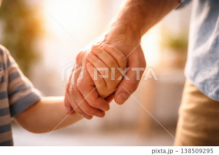 Close up of parent holding child hand with warm sunlight 138509295