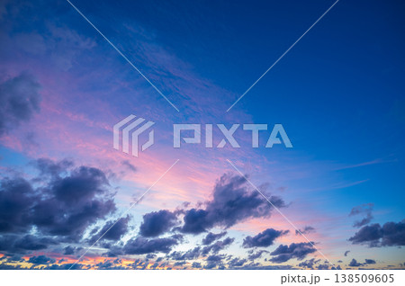 View of dramatic peaceful blue pink sky containing beautiful dark cloud formation during sunset sunrise dawn dusk creating majestic natural atmospheric background with tranquil mood View of dramatic peaceful blue pink sky containing beautiful dark cloud formation during sunset sunrise dawn dusk creating majestic natural atmospheric background with tranquil mood 138509605