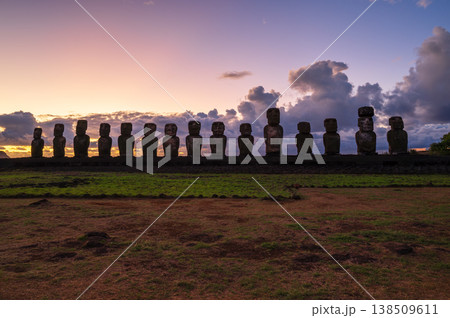 Majestic moai monument stands tall on easter island during peaceful sunset over rapa nui creating serene awe inspiring ancient landscape silhouette against colorful twilight sky Majestic moai monument stands tall on easter island during peaceful sunset over rapa nui creating serene awe inspiring ancient landscape silhouette against colorful twilight sky 138509611