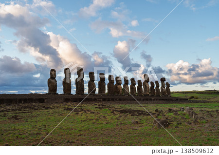 Majestic moai stand silent under dramatic cloud on easter island creating peaceful landscape across ancient rapa nui territory with mysterious stone monument history preserving old culture 138509612