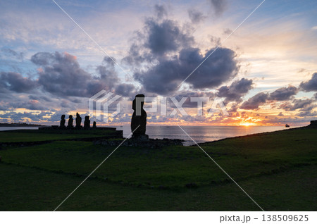 Serene moai statue of rapa nui faces beautiful warm sunrise over easter island ocean creating dark silhouette monument representing deep ancient travel history Serene moai statue of rapa nui faces beautiful warm sunrise over easter island ocean creating dark silhouette monument representing deep ancient travel history 138509625