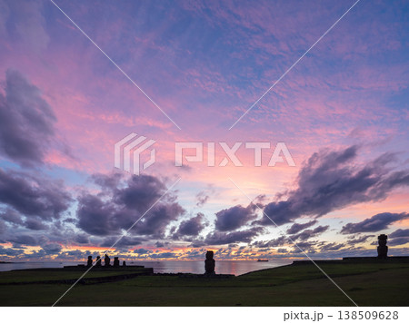 Majestic moai statue stands on tranquil rapa nui during beautiful pink sunset over easter island with dark silhouette against colorful sky cloud evoking deep sense of awe and wonder Majestic moai statue stands on tranquil rapa nui during beautiful pink sunset over easter island with dark silhouette against colorful sky cloud evoking deep sense of awe and wonder 138509628