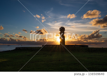 Majestic moai silhouette standing on easter island rapa nui glowing against scenic sunset sky over calm ocean radiating deep peaceful solitude and mysterious ancient wonder in nature 138509640