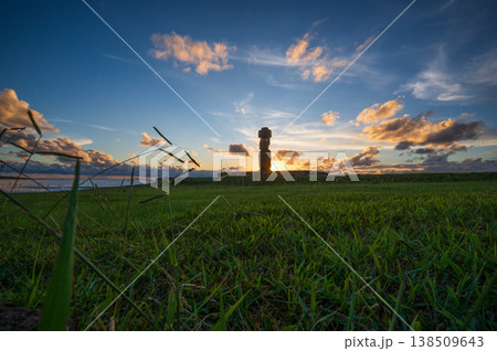 Ancient moai silhouette stands over green grass during beautiful sunset on easter island bringing deep feeling of mystery and wonder to remote archaeological landscape of rapa nui Ancient moai silhouette stands over green grass during beautiful sunset on easter island bringing deep feeling of mystery and wonder to remote archaeological landscape of rapa nui 138509643