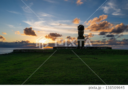 Majestic moai statue stands on green grass of easter island during peaceful sunset. beautiful sky over rapa nui inspires feelings of awe and mystical wonder for ancient history Majestic moai statue stands on green grass of easter island during peaceful sunset. beautiful sky over rapa nui inspires feelings of awe and mystical wonder for ancient history 138509645