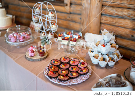 Mini cakes, biscuits and sweets displayed on table, closeup shallow depth of field photo Mini cakes, biscuits and sweets displayed on table, closeup shallow depth of field photo 138510128