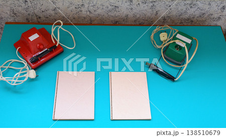 burning devices and notebooks on a turquoise table in a home workshop 138510679