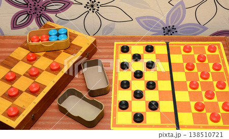 close up of a checkers board game with bright pieces on a wooden board and field 138510721