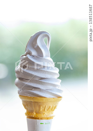 緑の背景に手持ちのソフトクリーム 北海道ミルクソフト 屋外で食べるスイーツ 夏の観光イメージ 138511687