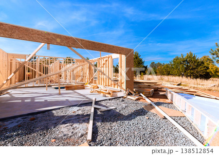 Wooden beams framing at construction site with building materials scattered around during framework 138512854