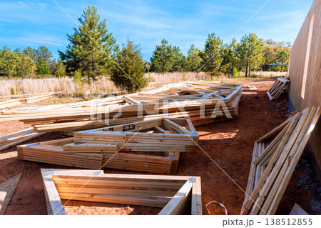 Wood beams, trusses frames pieces are placed on ground at construction site 138512855