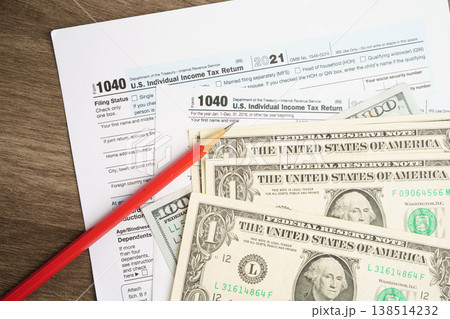Tax form 1040 U.S. Individual Income Tax Return with dollar banknotes money. Tax form 1040 U.S. Individual Income Tax Return with dollar banknotes money. 138514232