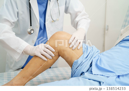 Doctor checking Asian elderly woman patient with scar knee replacement surgery in hospital. 138514233