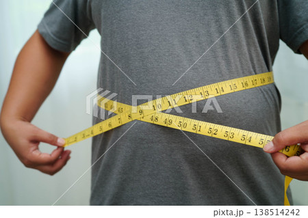 Asian woman with fat belly big size overweight and obesity with measure tape. 138514242