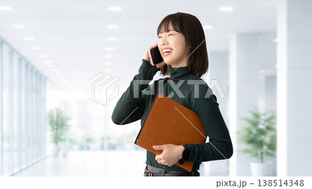 スマートフォンで話す笑顔の女性・ビジネスウーマン 138514348