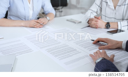 Business partners discussing contract terms, reviewing legal documents during an office meeting, focusing on agreement details and professional negotiation strategies Business partners discussing contract terms, reviewing legal documents during an office meeting, focusing on agreement details and professional negotiation strategies 138514705