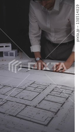 Architect drawing blueprints for a new residential building project, working late on construction plans. Concept of architecture and business in low key lighting 138514819