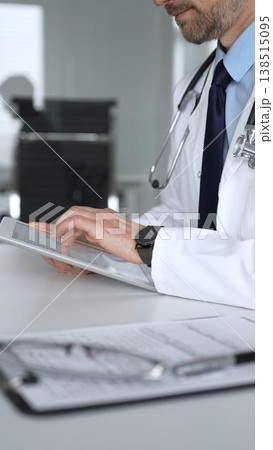 Doctor man interacting with patient during consultation, using digital tablet for modern medical healthcare technology. Medicine, healthcare and science concept Doctor man interacting with patient during consultation, using digital tablet for modern medical healthcare technology. Medicine, healthcare and science concept 138515095