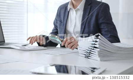 Professional auditor scrutinizing financial data and paperwork using a magnifying glass, performing a detailed tax investigation, legal discovery, and compliance analysis. Audit and taxes Professional auditor scrutinizing financial data and paperwork using a magnifying glass, performing a detailed tax investigation, legal discovery, and compliance analysis. Audit and taxes 138515332
