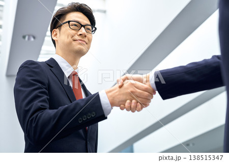 笑顔で握手を交わすビジネスマン 信頼と提携のビジネスイメージ 笑顔で握手を交わすビジネスマン 信頼と提携のビジネスイメージ 138515347