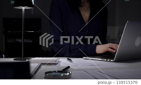 Businesswoman working late night typing on laptop at home office desk with documents and calculator. Audit and taxes in business Businesswoman working late night typing on laptop at home office desk with documents and calculator. Audit and taxes in business 138515370