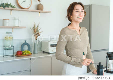 自宅のキッチンでコーヒーミルでコヒー豆を挽くアジア人女性 138515494