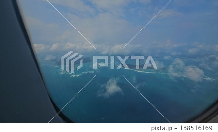 Airplane window view overlooking the spectacular turquoise waters and lush green tropical islands of the Andaman and Nicobar archipelago. Airplane window view overlooking the spectacular turquoise waters and lush green tropical islands of the Andaman and Nicobar archipelago. 138516169