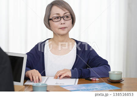 生命保険の契約書に署名捺印するシニア女性 138516853