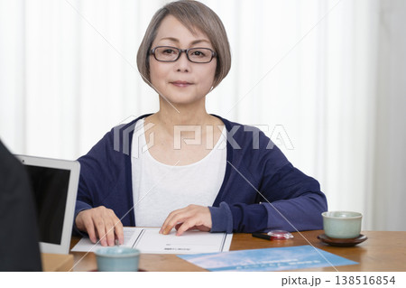 生命保険の契約書に署名捺印するシニア女性 138516854